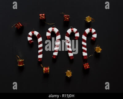 Natale candy canes tamburi cuori e doni a studio sopra vista su uno sfondo nero flatlay isolato Foto Stock