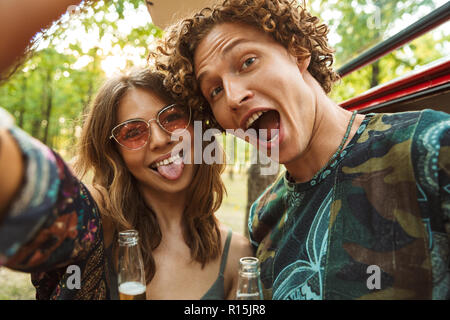 Gruppo di divertenti giovani amici prendendo selfie con un telefono  cellulare e rendere divertente volti all'aperto Foto stock - Alamy