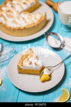 Cucina tradizionale francese dessert - deliziose torte al limone e meringa classica topping su uno sfondo blu Foto Stock