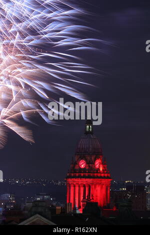 Fuochi d'artificio illuminano il cielo notturno dietro Leeds Town Hall per contrassegnare la fine del Leeds Interruttore Luci su evento 2018. Foto Stock