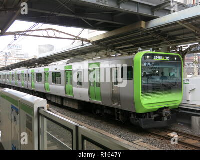 Un treno in arrivo presso la piattaforma sulla Linea Yamanote (JR East); stazione di Tokyo, Giappone Foto Stock