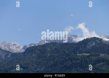 Parapendio volare sopra le foreste del Col de la Forclaz sopra il lago di Annecy Francia Foto Stock