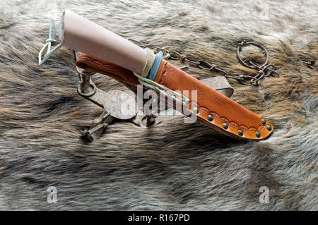 Un uomo di montagna coltello e fodero in cuoio visualizzati con una vecchia trappola e un castoro Nascondi Foto Stock