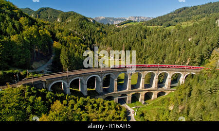 Treni passeggeri sul viadotto Semmeringbahn, Breitenstein, Rax, Austria Inferiore, Austria Foto Stock