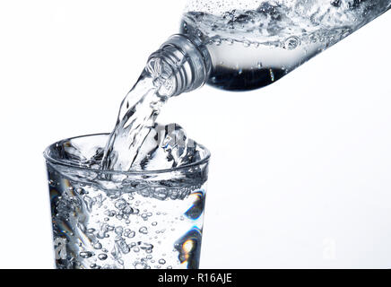 Acqua frizzante essendo versata nel bicchiere Foto Stock