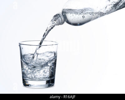 Acqua frizzante essendo versata nel bicchiere Foto Stock