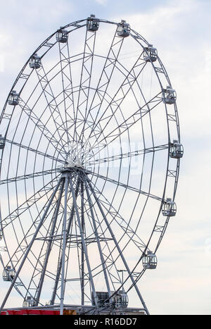 Carnival ride che mostra una filatura ruota panoramica Ferris in azione- lunga esposizione shot. Foto Stock