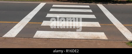 Una vista ravvicinata di un zerba attraversando il quale è dipinto di bianco di linee che vanno al di là della strada per i pedoni a camminare sopra in modo sicuro Foto Stock