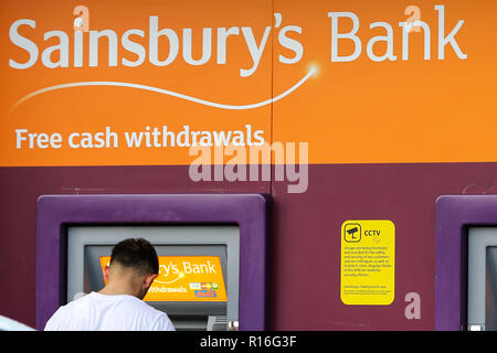 Londra, UK 9 Nov 2018. Una persona è vista utilizzando la macchina in contanti a Sainsbury's supermercato. A seguito di una sentenza della Corte di appello, i supermercati e i negozi di comodità non avrà più a pagare milioni di sterline di tariffe business per le macchine di contanti al di fuori dei loro negozi, dal 2010 i supermercati e i negozi di comodità sono state soggette al pagamento di tariffe su macchine e la corte di appello ha deliberato che circa £300m è già stata caricata e ora dovranno essere rimborsati. I negozi che sarà immediatamente beneficio includono Sainsbury's e Tesco, che aveva preso il caso in appello. Credito: Dinendra Hari Foto Stock