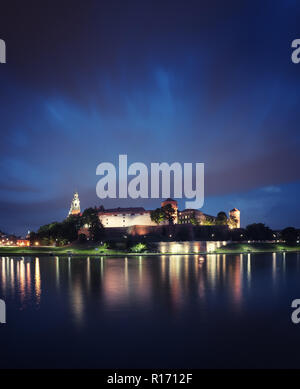 Il castello di Wawel durante la notte con il fiume Vistola presso il primo piano. Antico castello luci riflesso nell'acqua. Alta risoluzione panorama. Foto Stock