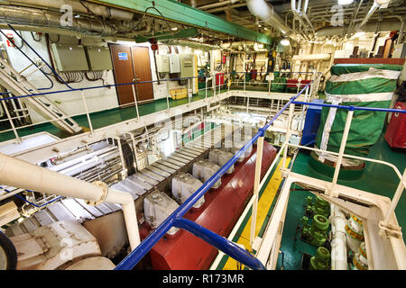 Vista panoramica del motore principale su di una nave mercantile nel vano motore con tutte le tubazioni, generatori e turbine, ecc. Foto Stock