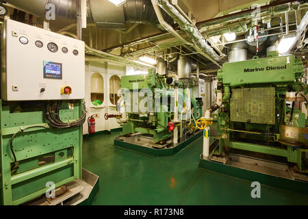 Vista panoramica di marine generatori diesel su una nave mercantile nella sala motori con tutte le tubazioni, generatori e turbine, ecc. Foto Stock