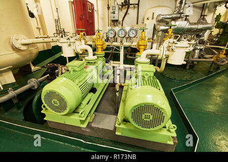 Vista panoramica di motori elettrici su di una nave mercantile nel vano motore con tutte le tubazioni, generatori e turbine, ecc. Foto Stock