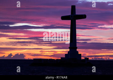 Croce cattolica silhouette nel cimitero affondata al crepuscolo, Camiguin island, Filippine Foto Stock