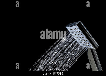 Moderna doccia calda con flusso di acqua closeup isolati su sfondo nero Foto Stock