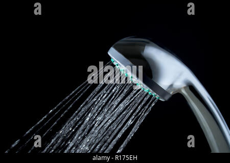 Moderna doccia calda con flusso di acqua closeup isolati su sfondo nero Foto Stock