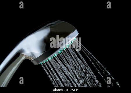 Moderna doccia calda con flusso di acqua closeup isolati su sfondo nero Foto Stock