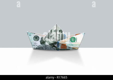 Forma di origami barca da US Dollari e sfondo grigio Foto Stock