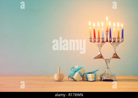 Immagine della festa ebraica Hanukkah sfondo con tradizionale top spinnig, menorah (tradizionale candelabro) e candele accese Foto Stock