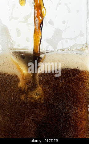 Progetto di Guinness/birra scura versando in un bicchiere, close up dettaglio Foto Stock