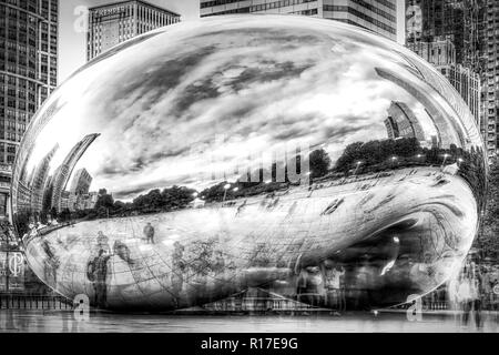 Pubblica un pezzo di arte si erge nel mezzo di edifici alti in Chicago lungo il lago in questa lunga esposizione che mostra la sfocatura della gente che si muove intorno ad esso. Foto Stock