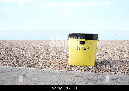 Un giallo lettiera su una spiaggia nella spiaggia di Brighton, Inghilterra. Foto Stock