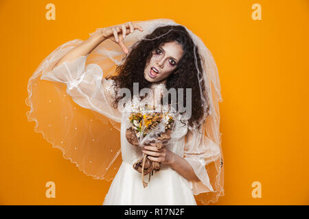 Creepy morti sposa in bianco abito da sposa guardando la fotocamera e scary isolate su Orange Foto Stock