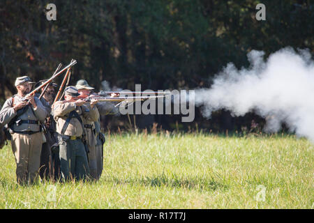 Famiglia MCCONNELLS, SC (USA) - 3 Novembre 2018: Reenactors in divise confederato fire un fucile volley in una ricreazione della Guerra Civile Americana. Foto Stock