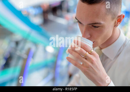 Giovani androgino omosessuale imprenditore LGTB di bere il caffè Foto Stock