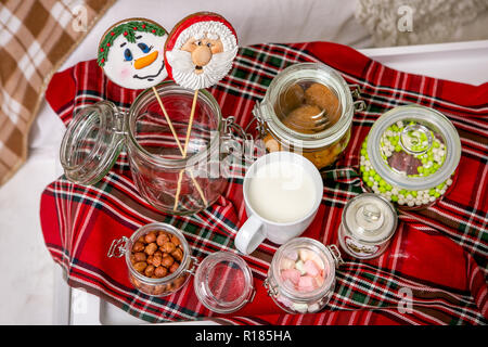 Gingerbread pupazzo di neve e Santa su un bastone sul tavolo per la colazione in camera da letto. Holiday dolci. Nuovo anno e tema natalizio. Atmosfera di festa. Foto Stock