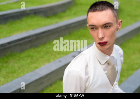 Giovani androgino omosessuale imprenditore LGTB indossando il rossetto Foto Stock