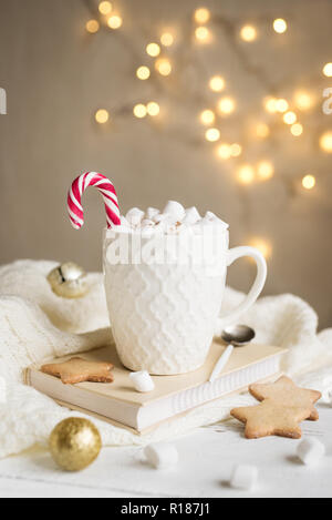 Il Natale di cioccolata calda con marshmallows, menta piperita candy cane in bianco mug, copia dello spazio. Cioccolata calda bevanda per le vacanze di Natale ed invernali con paglierino Foto Stock