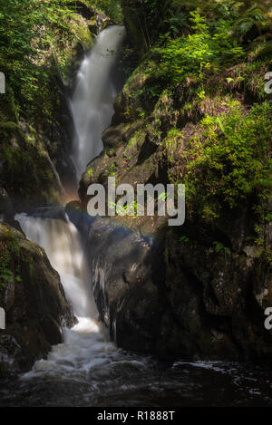 Gocce di acqua e luce del sole creando un effetto arcobaleno di fronte Aira Force, Lake Ullswater, Cumbria, Regno Unito Foto Stock