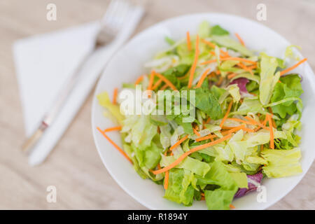 Fresca insalata di verdure sul vecchio tavolo in legno. Pasto vegano piastra su un tavolo di legno top Foto Stock