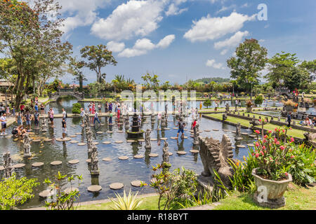 I turisti a piedi le pietre miliari di Taman Tirta Gangga acqua palace di Bali Foto Stock