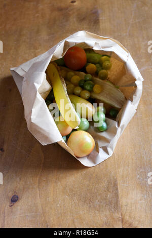 Maturazione pomodori verdi in un sacchetto di carta con le bucce di banana. Foto Stock