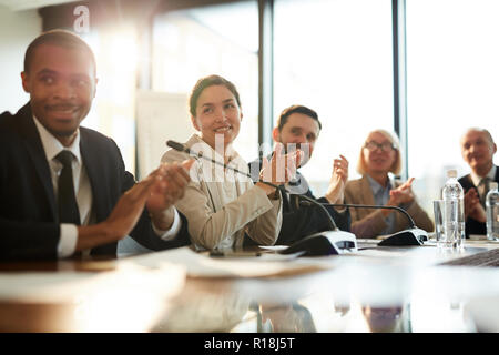 Felice giovani delegati battendo le mani dopo aver eseguito correttamente la relazione del relatore a conferenza Foto Stock