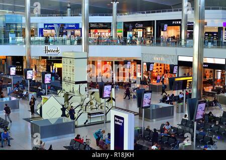 Londra, Inghilterra, Regno Unito. International lounge di partenza lungo con negozi duty free all'Aeroporto Internazionale di Heathrow. Foto Stock