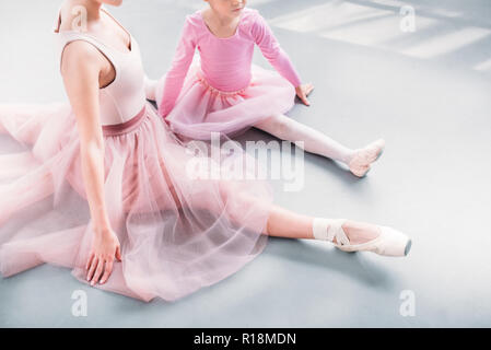Ritagliato colpo di insegnante di danza e un po' di stretching dello studente insieme in studio di balletto Foto Stock