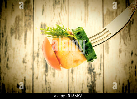 Fritti di carne con verdure closeup su una forcella su legno vintage schede di background. Vecchio stile grunge. Foto Stock