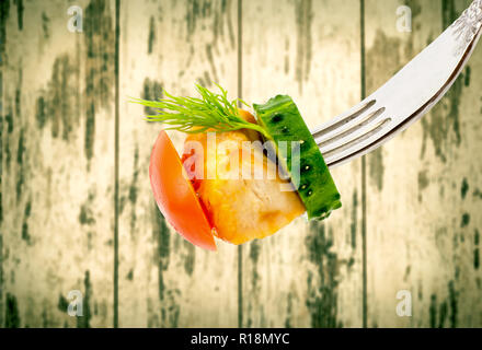 Fritti di carne con verdure closeup su una forcella su legno vintage schede di background. Vecchio stile grunge. Foto Stock