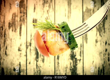 Fritti di carne con verdure closeup su una forcella su legno vintage schede di background. Vecchio stile grunge. Foto Stock