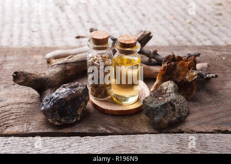 Bottiglie con emulsione, pietre e i dettagli in legno. Occulto, esoterico, divinazione e wicca concetto. Mystic, vecchia farmacia e sfondo vintage Foto Stock
