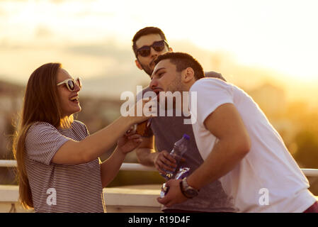 Un gruppo di giovani amici Bianco relax sulla terrazza in estate Foto Stock