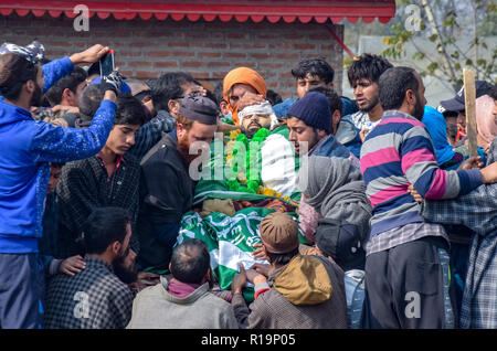 Novembre 10, 2018 - Pulwama, Jammu e Kashmir India - (NOTA DEL REDATTORE: immagine raffigura la morte.) i musulmani del Kashmir si vede radunati accanto al corpo morto di cadaveri militante Wajid-Ul-Islam durante il suo corteo funebre al suo villaggio natale babhara in Pulwama.Migliaia di persone hanno partecipato ai funerali preghiere dei due militanti che sono stati uccisi in uno scontro a fuoco con le forze di governo nel sud del Kashmir del distretto di Pulwama 40km dalla capitale estiva Srinagar. I militanti, secondo l Ispettore generale di polizia, Kashmir gamma, SP Pani, sono stati uccisi in un 'molto breve'' shootout in Tik Foto Stock