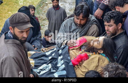 Novembre 10, 2018 - Pulwama, Jammu e Kashmir India - (NOTA DEL REDATTORE: immagine raffigura la morte.) parenti di uccisi militante Liyakat Ahmed si vede radunati accanto al suo cadavere durante il suo corteo funebre al suo villaggio natale di Pulwama.Migliaia di persone hanno partecipato ai funerali preghiere dei due militanti che sono stati uccisi in uno scontro a fuoco con le forze di governo nel sud del Kashmir del distretto di Pulwama 40km dalla capitale estiva Srinagar. I militanti, secondo l Ispettore generale di polizia, Kashmir gamma, SP Pani, sono stati uccisi in un 'molto breve'' sparatoria nel villaggio Tikken. (Credito Im Foto Stock