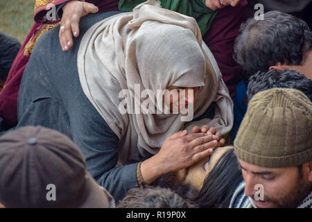 Novembre 10, 2018 - Pulwama, Jammu e Kashmir India - (NOTA DEL REDATTORE: immagine raffigura la morte.) Una relativa degli uccisi militante Liyakat Ahmed visto toccando il suo volto durante il suo corteo funebre al suo villaggio natale di Pulwama.Migliaia di persone hanno partecipato ai funerali preghiere dei due militanti che sono stati uccisi in uno scontro a fuoco con le forze di governo nel sud del Kashmir del distretto di Pulwama 40km dalla capitale estiva Srinagar. I militanti, secondo l Ispettore generale di polizia, Kashmir gamma, SP Pani, sono stati uccisi in un 'molto breve'' sparatoria nel villaggio Tikken. (Credito Immagine: © Id Foto Stock