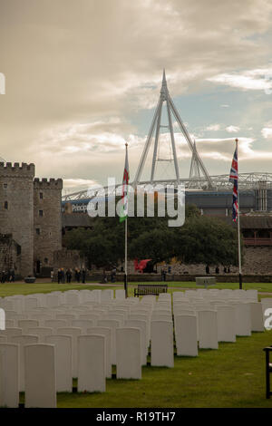 Cardiff, Regno Unito. Il 10 novembre 2018. I visitatori e i sostenitori di rugby presso la replica Commonwealth War Graves cimitero della Commissione installati presso il cortile del Castello di Cardiff per il centenario di armistizio, prima del Galles versetti Australia rugby gioco al Principato Stadium, visto in background. Credit Haydn Denman/Alamy Live News Foto Stock