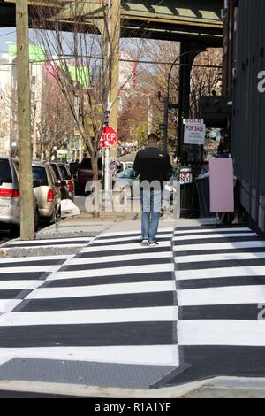 New York, NY, STATI UNITI D'AMERICA. Il 10 Novembre, 2018. Un tratto di Brooklyn, New York il marciapiede, è stata trasformata in una scacchiera di riquadri bianchi e neri attraverso una patch di pavimentazione al di fuori di un lussuoso appartamento nuovo edificio e negozio boutique di rischio e una galleria di immagini in rapida gentrified quartiere di Bushwick. Il Dipartimento dei trasporti dice che la gente non può legalmente marciapiedi di vernice e arte non autorizzato riceve tipicamente una multa, con i proprietari di solito ottenere trenta giorni di tempo per rimuovere il loro lavoro prima di una sanzione ufficiale segue. © 2018 G. Ronald Lopez/DigiPixsAgain.us/Alamy Live News Foto Stock