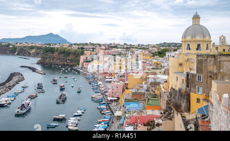 Marina Corricella, colorato villaggio di pescatori sull'isola di Procida nel Golfo di Napoli, Italia. Foto scattata dalla cima della scogliera. Foto Stock